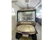 Tan golf cart with custom paint in garage at 2530 Saffron Ln, The Villages, FL 32162
