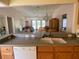 Kitchen with wood cabinets, double sink, and view to living area at 2530 Saffron Ln, The Villages, FL 32162