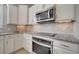 This kitchen features granite counters, stainless appliances, white cabinets, tile backsplash and a range hood at 2724 Matera Dr, Saint Cloud, FL 34771