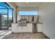 Outdoor kitchen features stainless steel grill, granite countertops, beverage cooler, and white cabinets in screened patio at 2724 Matera Dr, Saint Cloud, FL 34771