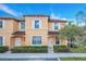 Two-story townhome with light peach exterior, landscaping, and a sidewalk at 2740 Coupe St, Kissimmee, FL 34746