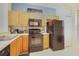Kitchen with light wood cabinets, black appliances, and a mosaic backsplash at 2740 Coupe St, Kissimmee, FL 34746