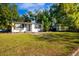 Front exterior view of the home with mature landscaping, walkway, and a lush, green lawn at 2803 E Pine St, Orlando, FL 32803