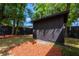 Storage shed in the fenced backyard with mature trees creating a shady space at 2803 E Pine St, Orlando, FL 32803