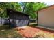 View of a storage shed in the backyard with mulch beds, next to the side of the house at 2803 E Pine St, Orlando, FL 32803