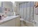 Bright bathroom features a vanity with a white countertop, a framed mirror, and a shower with a gold curtain at 2868 N Powers Dr # 5, Orlando, FL 32818