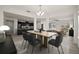 Dining area features a modern chandelier and seating for six, adjacent to kitchen and living room at 4032 Prairie Reserve Blvd, Orlando, FL 32824