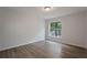 Bright bedroom with wood-look flooring and large window at 5436 E Michigan St # 4, Orlando, FL 32812