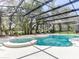 Relaxing pool and spa with lounge chairs in a screened enclosure at 6112 Broad Oak Dr, Davenport, FL 33837