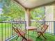 Relaxing balcony with table and chairs, offering a view of lush green space at 7350 Westpointe Blvd # 224, Orlando, FL 32835