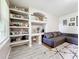 Living room with sectional sofa, built in shelving, and hardwood floors at 7350 Westpointe Blvd # 224, Orlando, FL 32835