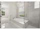 Modern bathroom with soaking tub, glass enclosed shower, and a chandelier at 7399 Gathering Ct, Reunion, FL 34747