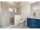 Modern bathroom boasting a glass-enclosed shower, blue vanity with marble countertop, and sleek fixtures at 7399 Gathering Ct, Reunion, FL 34747