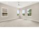 Bright bedroom featuring neutral walls, plush carpeting, and plenty of natural light from multiple windows at 7399 Gathering Ct, Reunion, FL 34747