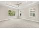 Bright bedroom with tray ceiling, fan, plush carpet, and three windows offering plenty of natural light at 7399 Gathering Ct, Reunion, FL 34747