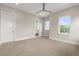 Bright bedroom with neutral walls, carpet floors, fan, and ensuite bathroom access at 7399 Gathering Ct, Reunion, FL 34747