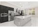 Sleek kitchen featuring a large island, stainless steel appliances, and modern cabinetry, designed for both style and functionality at 7399 Gathering Ct, Reunion, FL 34747