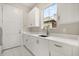 Bright laundry room featuring modern cabinets, quartz counters, and stainless sink at 7399 Gathering Ct, Reunion, FL 34747