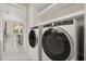 Stylish laundry area with modern washer and dryer, adjacent to the kitchen at 7399 Gathering Ct, Reunion, FL 34747