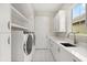 Well-appointed laundry room with sleek cabinets, quartz counters and modern appliances at 7399 Gathering Ct, Reunion, FL 34747