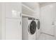 Modern laundry room with front-loading washer and dryer and ample storage at 7399 Gathering Ct, Reunion, FL 34747