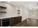 Open living room featuring a wet bar, sleek cabinets, and hardwood floors at 7399 Gathering Ct, Reunion, FL 34747