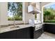 Outdoor kitchen with stainless steel grill, granite counter and sink at 7399 Gathering Ct, Reunion, FL 34747