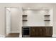 Contemporary wet bar with custom cabinetry, dark wood, and under-counter beverage center at 7399 Gathering Ct, Reunion, FL 34747