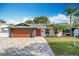 Refreshed home exterior features a new garage door and landscaping at 744 London Rd, Winter Park, FL 32792