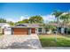 Updated home exterior boasts a modern look with new paint, landscaping, and driveway at 744 London Rd, Winter Park, FL 32792