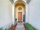Inviting entryway with arched entry, orange door, and welcome sign at 8030 King Palm Cir, Kissimmee, FL 34747