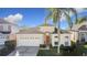 Attractive single-story house with a two-car garage, landscaping, and palm tree at 8030 King Palm Cir, Kissimmee, FL 34747