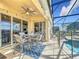 Covered patio with seating area, adjacent to pool and screened enclosure at 8030 King Palm Cir, Kissimmee, FL 34747