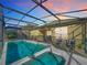 Screened pool and spa with patio seating at sunset at 8030 King Palm Cir, Kissimmee, FL 34747