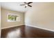 Bright bedroom with dark hardwood floors and a window at 8436 Tangelo Tree Dr, Orlando, FL 32836