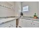 Laundry room with granite countertop, white cabinets, and a utility sink at 9085 Yonath St, Orlando, FL 32827