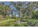 Landscaped garden with a sundial, lush greenery, and a lake view at 1120 Preserve Point Dr, Winter Park, FL 32789