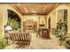 Covered outdoor kitchen with fireplace, bar seating, and lush landscaping at 1120 Preserve Point Dr, Winter Park, FL 32789