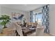 Dining room features a wood table, neutral chairs, and large art at 1261 Limbali St, Mount Dora, FL 32757