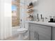 Modern bathroom with a soaking tub, gray vanity, and wood-look tile at 13188 Sw 35Th Cir, Ocala, FL 34473