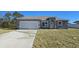 Newly constructed one-story home with gray exterior, attached garage, and a well-maintained lawn at 13188 Sw 35Th Cir, Ocala, FL 34473