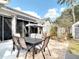 Backyard patio with a dining table, swing, wicker chair, and well-maintained landscaping and a garden at 2122 King Richards Ct, Orange City, FL 32763
