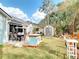 Spacious backyard featuring an outdoor kitchen, patio area, garden, shed, and lush greenery at 2122 King Richards Ct, Orange City, FL 32763