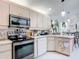 Modern kitchen with updated appliances, ample counter space, and white cabinets at 2122 King Richards Ct, Orange City, FL 32763