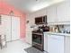 Bright kitchen with modern appliances, white cabinets, and stylish countertops, adjacent to pantry and laundry area at 2122 King Richards Ct, Orange City, FL 32763