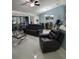 Open-concept living room with sliding glass doors, ceiling fan, and modern furniture at 2122 King Richards Ct, Orange City, FL 32763