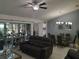 Open-concept living and dining area with sliding glass doors leading to a sunroom, complete with a ceiling fan at 2122 King Richards Ct, Orange City, FL 32763