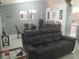 Inviting living room with modern decor, a leather sofa, tile flooring, and an adjacent dining area at 2122 King Richards Ct, Orange City, FL 32763