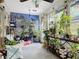 Bright sun room filled with natural light from large windows covered in lush green plants and decor at 2122 King Richards Ct, Orange City, FL 32763