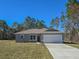 Newly constructed home with gray siding, red door, and a two-car garage at 406 Marion Oaks Pass, Ocala, FL 34473